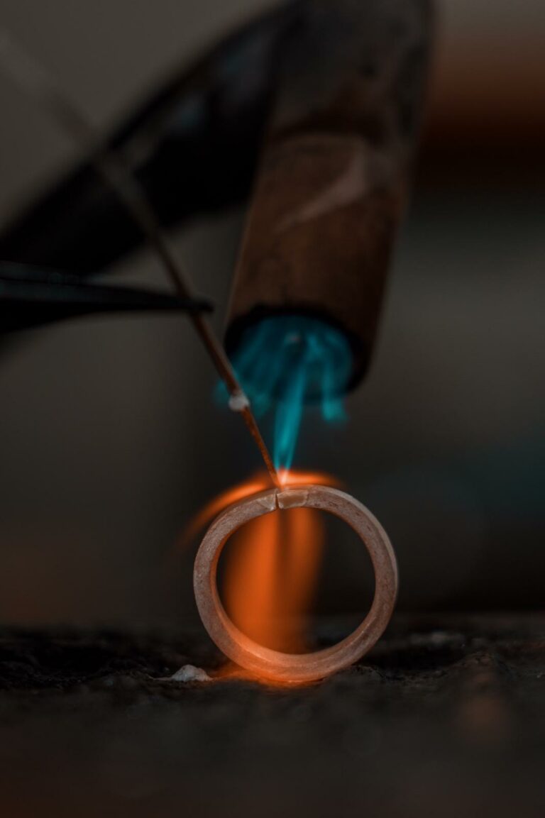 A silversmith smelts a ring.