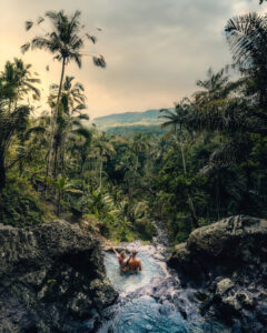 A couple relax in one of the waterfalls in bali