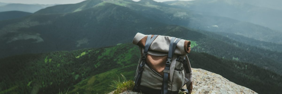 a hiking day pack on a boulder overlooking mountains